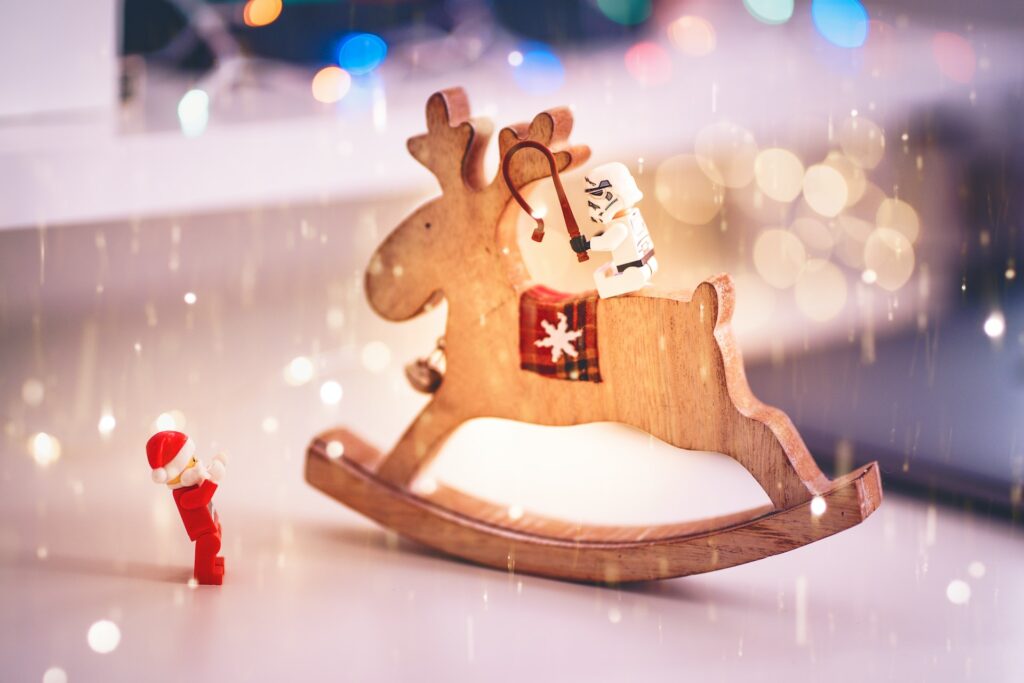 Lego figurines playing on a Reindeer rocking horse. Image credit Remy_Loz, https://unsplash.com/photos/VaTRbac_XIM